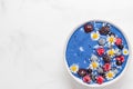 Healthy breakfast dessert. blue spirulina smoothie bowl with fresh and frozen berries, coconut and chamomile flowers Royalty Free Stock Photo
