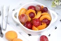 Healthy breakfast, food for children, fruit salad with peaches, pear, grapes on a bright table. The concept of healthy and natural