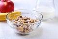 Healthy breakfast. Fresh granola, muesli with coconut, banana apple and nuts with milk in a white bowl on textile Royalty Free Stock Photo