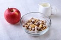 Healthy breakfast. Fresh granola, muesli with coconut, banana apple and nuts with milk in a white bowl on textile Royalty Free Stock Photo