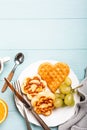 Healthy breakfast with fresh hot waffles hearts, pancakes flowers