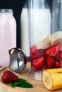 Healthy breakfast with fresh strawberries, bananas and yogurt in a blender. Ingredients for milkshake. Royalty Free Stock Photo