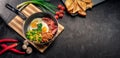 Healthy breakfast with fried eggs, bacon, beans, toasts, mushrooms, broccoli and tomatoes on black background