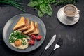 Healthy breakfast fried eggs with greens and croutons on black background Royalty Free Stock Photo