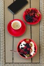 Healthy breakfast on garden furniture: cottage cheese with sour cream, strawberry, raspberry and blueberry, espresso Royalty Free Stock Photo