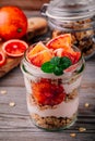 Healthy breakfast glass jar yoghurt parfait with homemade granola and blood orange on a wooden background Royalty Free Stock Photo