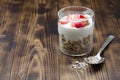 Healthy breakfast. Glass yogurt, fresh strawberry,  spoon with the scattered granule on a wooden table. Copyspace Royalty Free Stock Photo