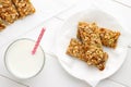 Healthy breakfast with granola bars and milk on white wooden table. Royalty Free Stock Photo