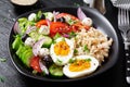 Greek inspired savory oatmeal with fresh cucumber, tomatoes, olives, lettuce, mozzarella cheese and boiled egg