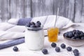 A healthy breakfast of Greek yogurt in a glass jar and fresh blueberries and jam at a rustic white table. Selective focus on glass Royalty Free Stock Photo