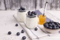 A healthy breakfast of Greek yogurt in a glass jar and fresh blueberries and jam at a rustic white table. Selective Royalty Free Stock Photo
