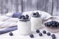 A healthy breakfast of Greek yogurt in glass jars and fresh blueberries at a rustic white table. Selective focus on glass jar in Royalty Free Stock Photo