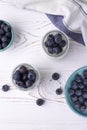 A healthy breakfast of Greek yogurt in glass jars and fresh blueberries at a rustic white table. Vertical, flat lay Royalty Free Stock Photo