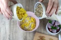 Healthy breakfast. Grey ceramic bowl with granola, strawberry and nuts in woman`s hands. Royalty Free Stock Photo