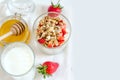 Healthy breakfast of homemade granola cereal with strawberry, nuts and fruit, honey with drizzlier background. Morning food, Diet,