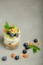 Healthy breakfast homemade: yogurt parfait with granola, berries and kiwi, fruit salad on stone background