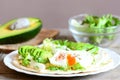 Healthy breakfast idea. Delicious tortilla with a poached egg, avocado slices, napa cabbage, salad mix, sauce and spices Royalty Free Stock Photo