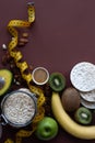 Healthy breakfast ingrediens. Homemade granola in open glass jar, honey, nuts, fruits, yellow tape-lane on brown background. Royalty Free Stock Photo