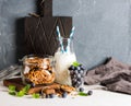 Healthy breakfast ingrediens. Homemade granola in open glass jar, milk or yogurt bottle, blueberries and mint Royalty Free Stock Photo