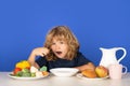 Healthy breakfast lunch for kids. Little kid boy have a dinner. Hungry face and enjoy eating enjoy food concept. Child