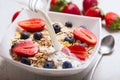 Healthy breakfast. Milk pouring into bowl of muesli with fresh berries Royalty Free Stock Photo