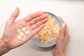 Healthy breakfast in morning: woman hand holding tasty flakes over bowl with cereal in female arm Royalty Free Stock Photo