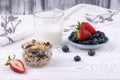 Healthy breakfast with muesli and fresh strawberries and blueberries  milk on a white wooden table in rustic style  close-up Royalty Free Stock Photo