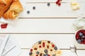 Healthy breakfast with oat flakes, berries, croissants on the white wooden table with copy space, top view Royalty Free Stock Photo