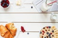 Healthy breakfast with oat flakes, berries, croissants on the white wooden table with copy space, top view Royalty Free Stock Photo