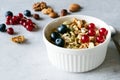 Oat flakes with berries, nuts, pumpkin seeds in a ceramic bowl on a grey background. Royalty Free Stock Photo