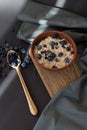 Healthy breakfast. Oat granola with fresh blueberries and currants in a clay bowl over dark grunge surface. Top view