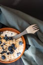 Healthy breakfast. Oat granola with fresh blueberries, currants and milk in a clay bowl over dark grunge surface. Top view Royalty Free Stock Photo