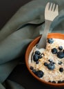 Healthy breakfast. Oat granola with fresh blueberries, currants and milk in a clay bowl over dark grunge surface Royalty Free Stock Photo