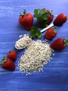 Healthy breakfast oatmeal, bananas and strawberries on wooden background.