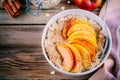 Healthy breakfast: oatmeal bowl with caramelized apples, cinnamon and honey Royalty Free Stock Photo