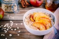 Healthy breakfast: oatmeal bowl with caramelized peaches, cinnamon and honey