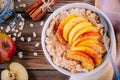 Healthy breakfast: oatmeal bowl with caramelized peaches, cinnamon and honey Royalty Free Stock Photo