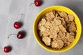 healthy breakfast oatmeal corn flakes in a bowl of yellow with cherry berries on a gray background with space for text copyspace Royalty Free Stock Photo