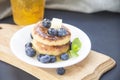 A healthy breakfast of pancakes, berries, butter, and honey