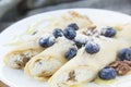 A healthy breakfast of pancakes, walnut, berries, butter, and honey