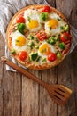 Healthy breakfast pizza with eggs, broccoli, tomatoes and parsley close-up. Vertical top view Royalty Free Stock Photo