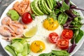 Healthy breakfast with salmon, boiled shrimps, prawns, fried eggs, fresh salad, tomatoes, cucumbers and avocado. keto diet. Top Royalty Free Stock Photo