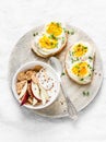 Healthy breakfast - sandwiches with cream cheese and boiled egg, yogurt with apple and flax seeds on light background