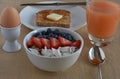 Healthy Breakfast Scene with grapefruite juice, boiled egg, sprouted grain toast, and steel cut oatmeal with fruit.