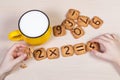 Healthy breakfast for a school children. Milk in bright yellow cup and funny cookies with numbers.