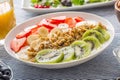 Healthy breakfast served with plate of yogurt muesli kiwi strawberries and banana