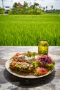 Healthy breakfast served on a vintage table with an emerald green rice field background. Concept of a healthy food and healthy Royalty Free Stock Photo