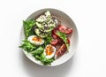 Healthy breakfast, snack bowl - boiled egg, tomatoes, avocado cottage cheese seeds sandwich, green salad on a light background, Royalty Free Stock Photo