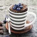 Healthy breakfast or snack. Chocolate mug cupcake with blueberries and chocolate chips in a gray striped ceramic mug on Royalty Free Stock Photo