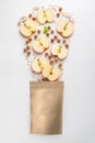 Healthy breakfast and snack concept. Top view of granola ingredients fall into paper bag on white background Royalty Free Stock Photo